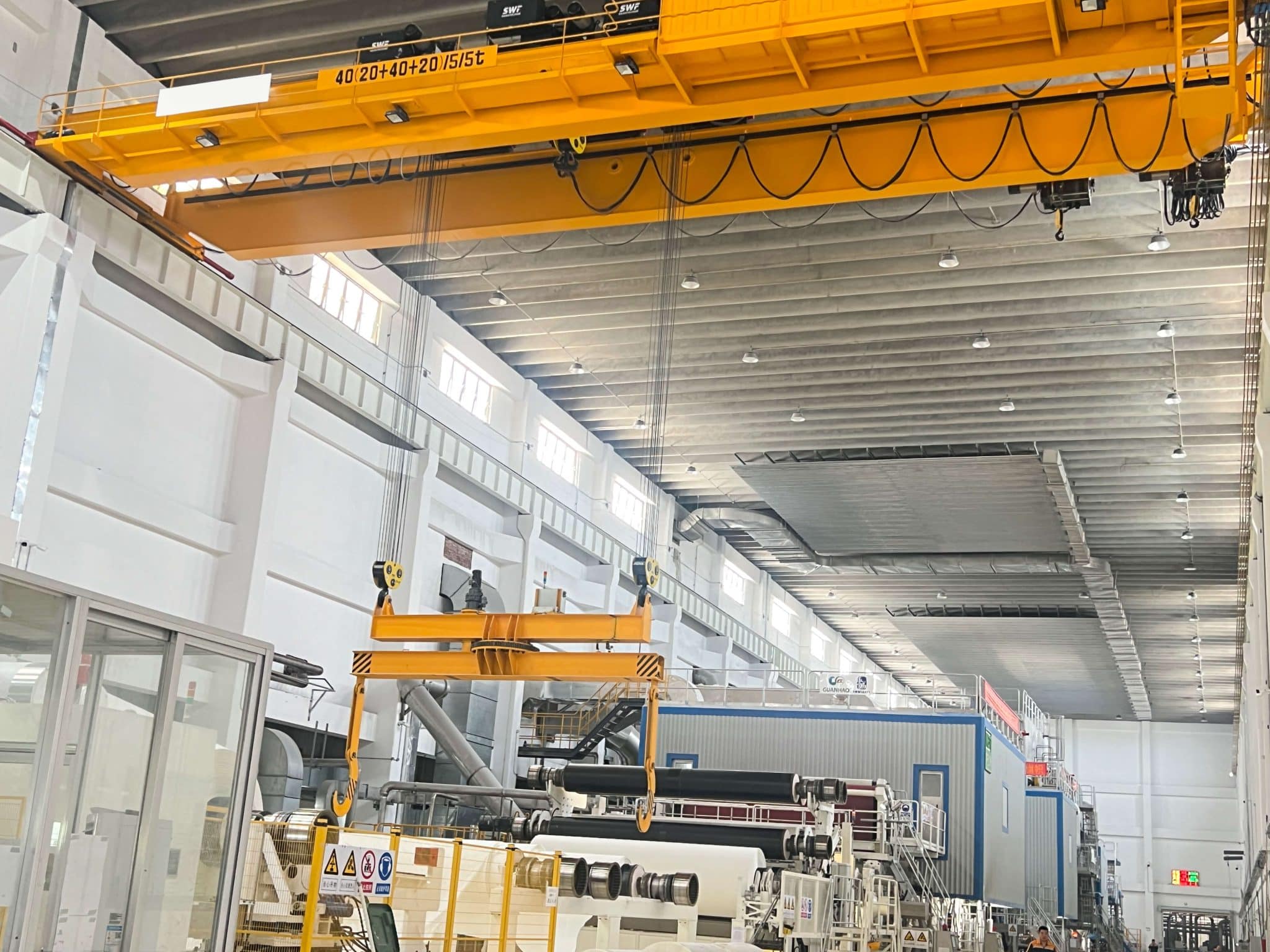 Paper roll handling crane serving a finished roll warehouse
